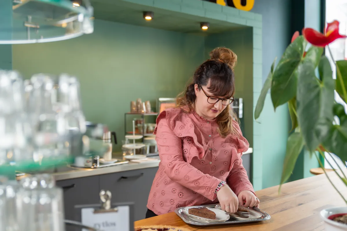 Mitarbeiterin beim Kuchen servieren